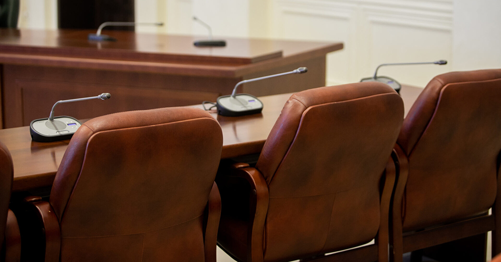 An empty council chamber showing microphones on desks.