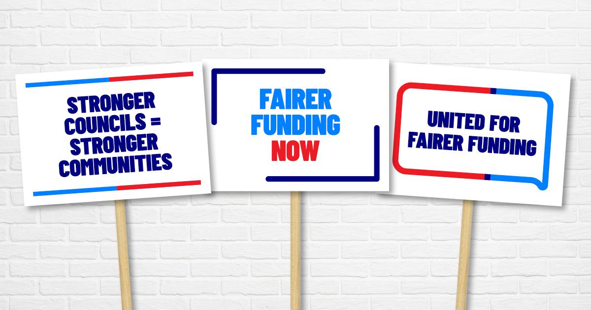 Three protest-style placards displaying the messages "Stronger councils = stronger communities", "Fairer funding now" and "United for fairer funding".