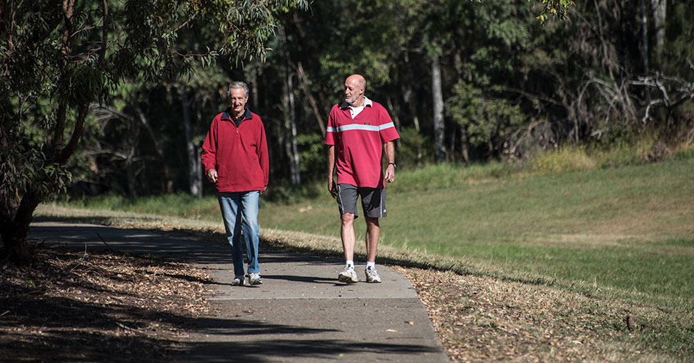 Two men enjoying a morning walk in a bush setting along a council walking path