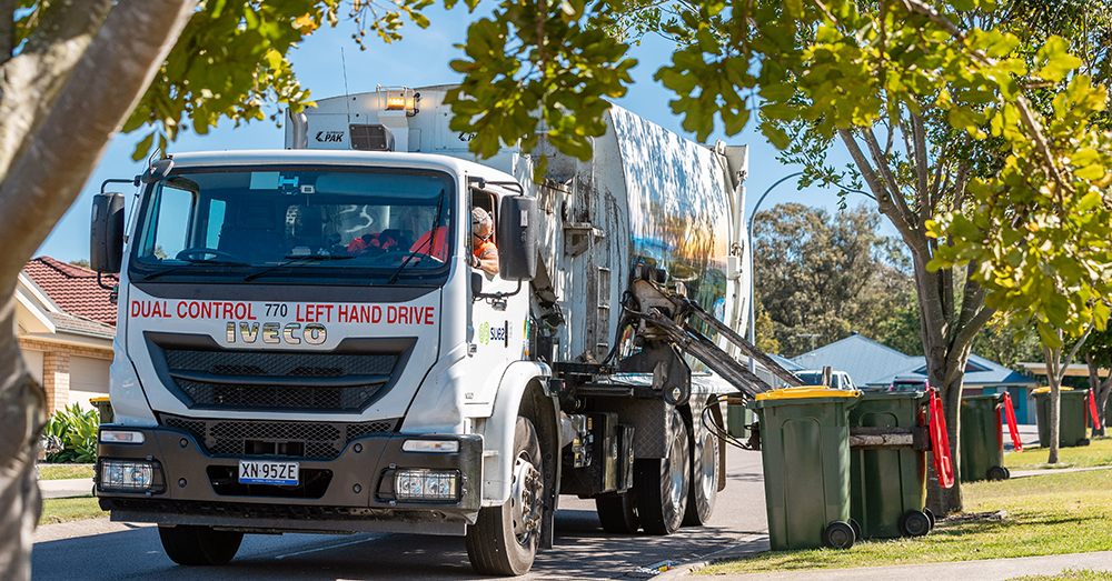 A Port Stephens waste trucks empties a residential wheelie bin.