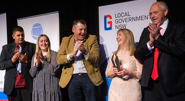 People celebrate a win onstage at an LG Week awards night.