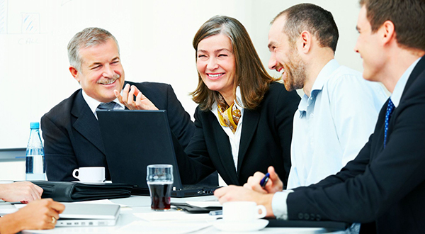 Two men and two women looking jovial in a group discussion.